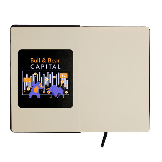 An A5 notebook with a black cover and an illustration featuring a bull and bear on the inner page, includes a logo.
