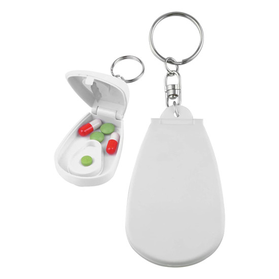A white pill cutter with a keychain attachment, featuring an open compartment with green and red pills inside.