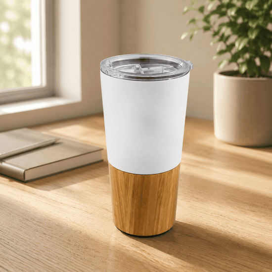 A travel mug featuring a white upper portion and a bamboo lower section, with a clear lid and a logo.