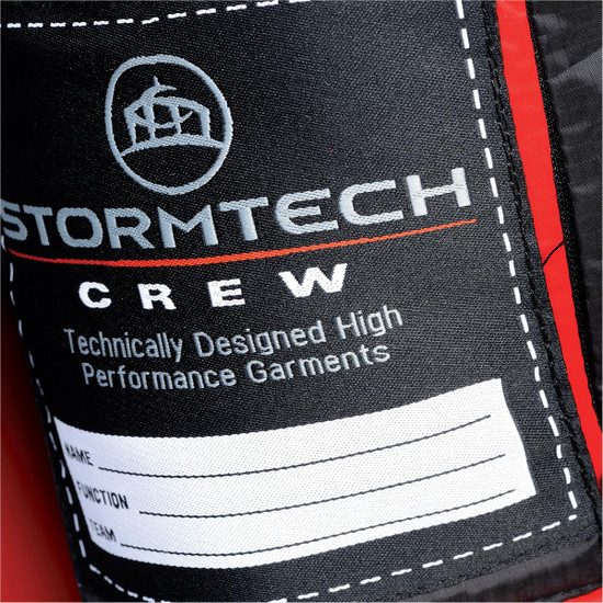 A close-up of a label on a red puffer jacket, featuring a logo and space for personal details.