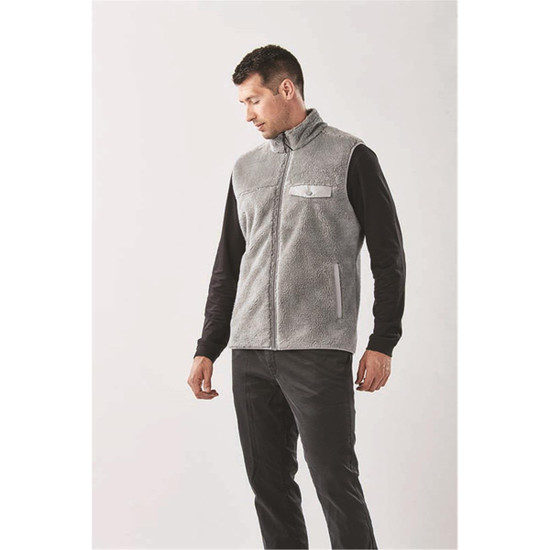 A men's grey sherpa fleece vest with a front zipper and a pocket, modelled by a man.