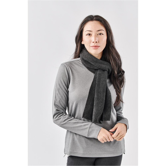 A woman wearing a dark grey Avalante Knit Scarf over a grey top, posing against a neutral background.
