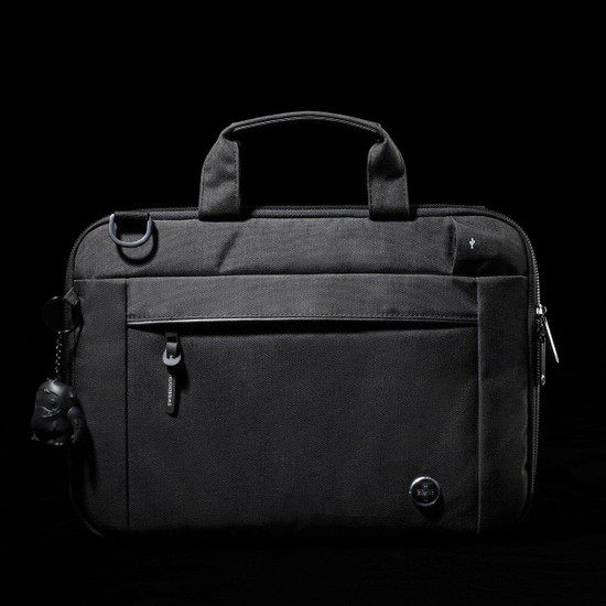 A black laptop sleeve with a zippered front pocket, handle, and a keychain accessory. It features a logo.
