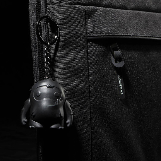 A black laptop sleeve features a textured surface and a keychain with a small black character.