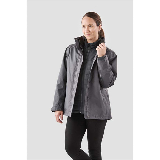 A woman wearing a grey Women's Magellan System Jacket, featuring a zipped inner layer and a relaxed fit.