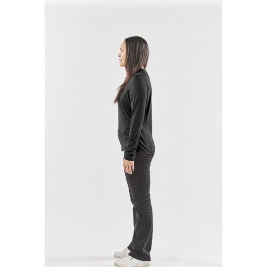 A side view of a woman wearing a black long-sleeve crew neck shirt and black pants, with a logo on the shirt.