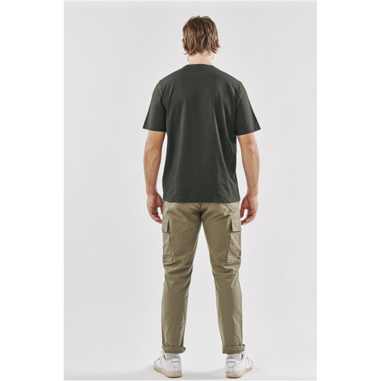 A green men's t-shirt viewed from the back, paired with light tan cargo pants and white shoes. The shirt features a logo.