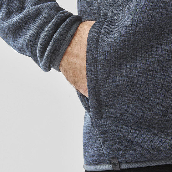 A grey polar fleece jacket featuring a side pocket and a fitted design at the cuffs. It has a logo on the hem.