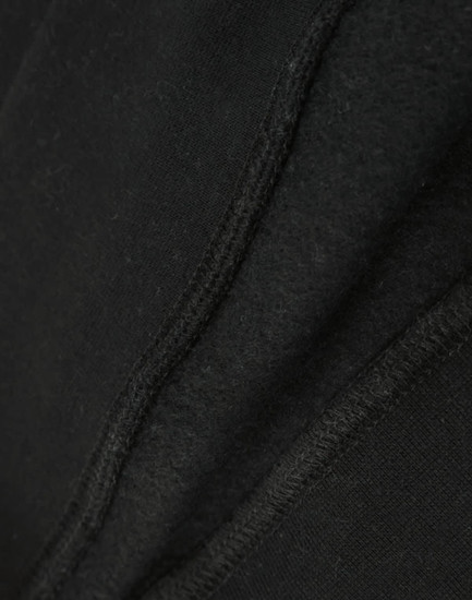 A close-up view of a black crew fleece sweat, highlighting its textured fabric and stitching details.