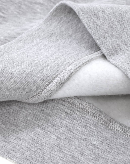 A close-up of a grey crew fleece sweatshirt showing the soft interior fabric and detailed stitching.