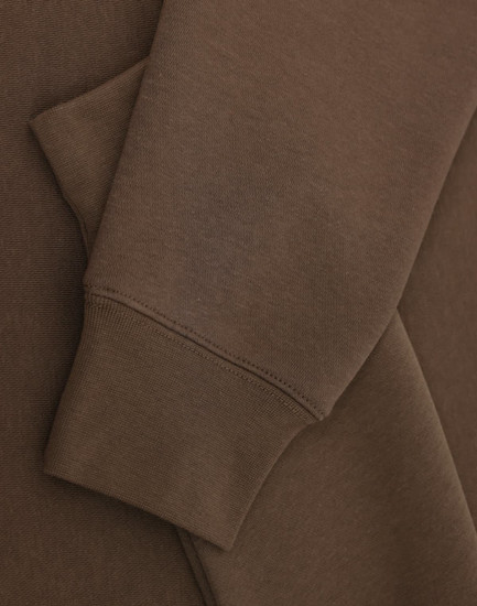 A brown crew fleece jumper with visible cuffs and fabric texture detail. Features a logo.