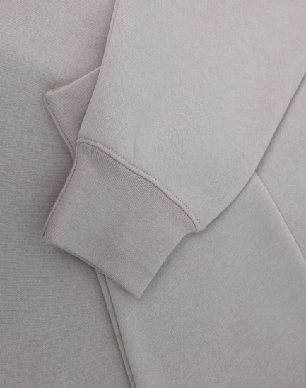 A light grey polar fleece jumper featuring a half zip collar and fitted cuffs. It has a subtle logo.