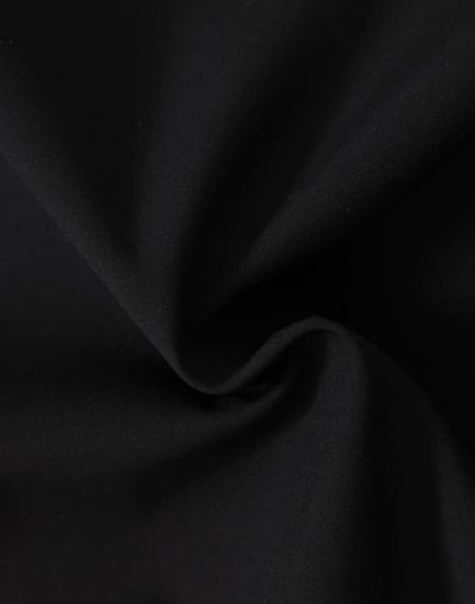 A close-up of black fabric featuring a soft texture, ideal for softshell jackets.