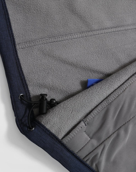 A close-up of a navy softshell hoodie featuring a grey fleece lining and a drawstring at the hem.