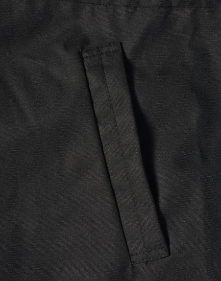 A close-up of a black fabric featuring a stitched pocket on a jacket. The material appears durable and textured.