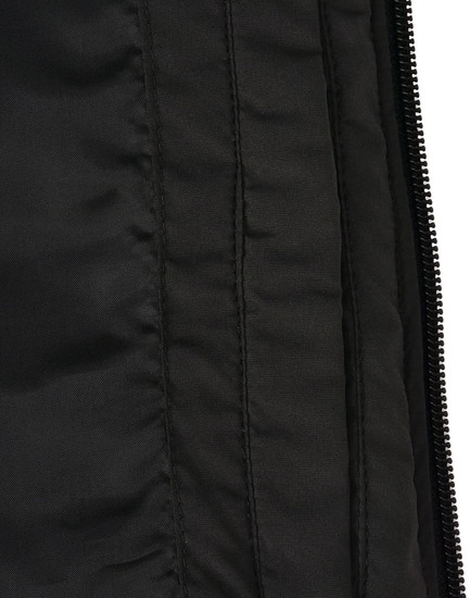 A close-up of a black parka jacket showing the textured fabric and inner lining details. It features a zipper and stitching.