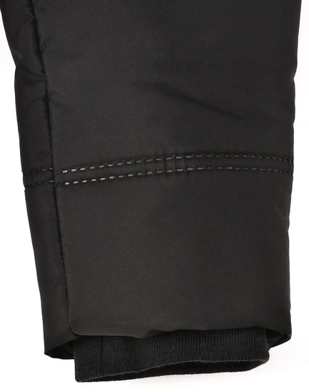 A close-up of a black sustainable parka jacket featuring a seamless design and detailed stitching at the cuff.
