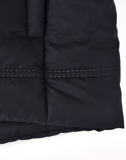A close-up of a black seamless parka jacket, featuring a textured fabric and contrasting stitching details.