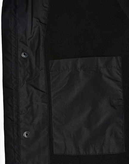 A unisex black jacket featuring a smooth fabric and a patch pocket. It includes snaps for closure and a logo.