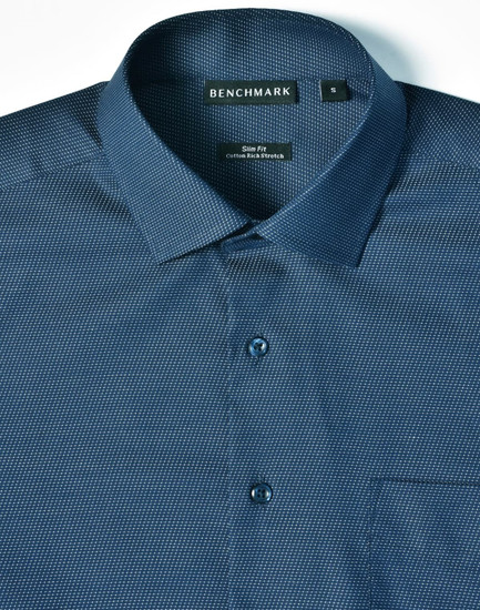 A blue pin dot button-up shirt with a slim fit design, featuring a collar and pocket. It has a branding label.