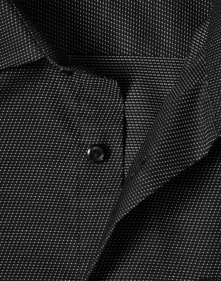 A black long-sleeve button-up shirt featuring a pin dot pattern and a collar, with a logo present.