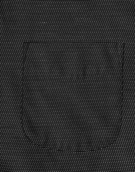 A close-up view of a black pin dot fabric featuring a pocket, showcasing a textured pattern.