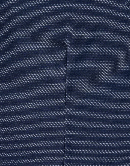 A close-up of a navy blue fabric with a pin dot pattern, showcasing the texture of the shirt.