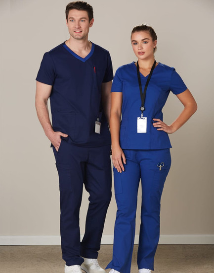 A navy blue and royal blue scrub top is worn by a model, featuring short sleeves and a logo.