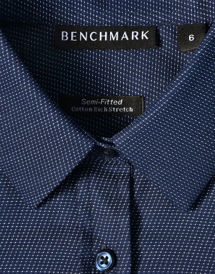 Ladies' pin dot stretch long sleeve shirt in navy with a button closure, featuring a logo label inside the collar.