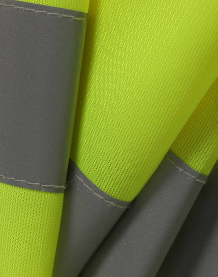 A close-up of a bright yellow safety vest featuring grey shoulder reflective tapes and textured fabric.