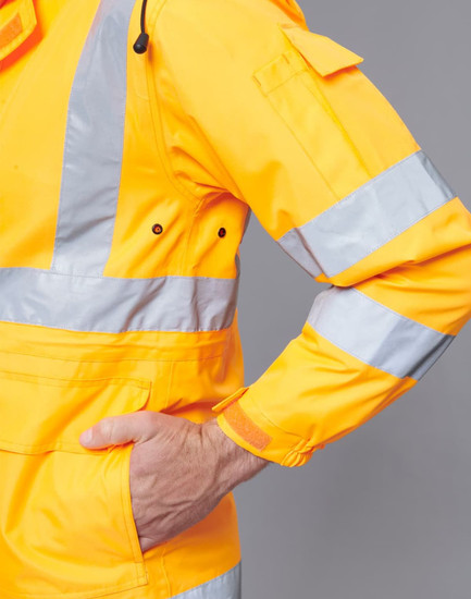 A bright yellow safety jacket with reflective stripes, featuring a pocket and adjustable cuffs. It has a logo.