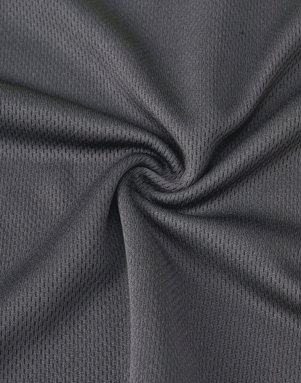 A textured, dark grey fabric showcasing the breathable mesh of a unisex polo shirt designed for workwear.