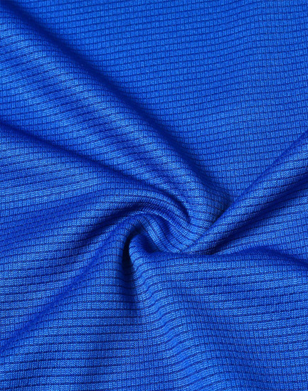 A close-up of textured blue fabric, showcasing a lightweight, performance material ideal for t-shirts.