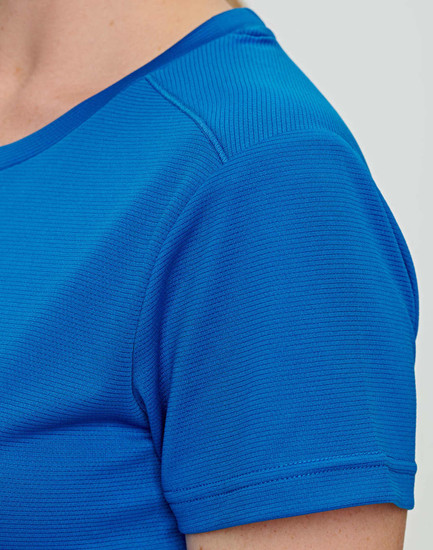 A close-up of a blue ladies' short-sleeve T-shirt, featuring a textured fabric and a logo.
