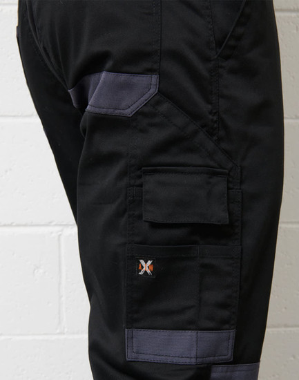 A close-up of black cargo pants featuring grey accents and a logo on the side.