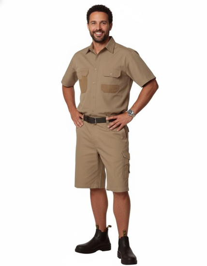 A man stands confidently wearing khaki heavy duck weave work shorts with pockets, paired with black footwear.