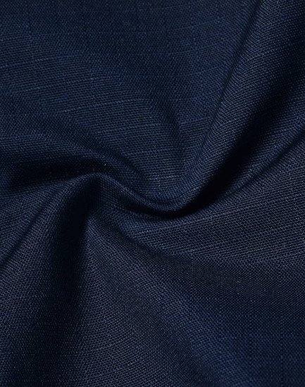 A close-up view of navy rip-stop poly/cotton fabric, showcasing its textured weave and stretch properties.