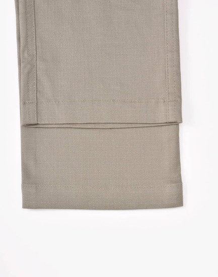 Unisex cotton stretch ripstop work pants in a light beige shade, showcasing a smooth, flat hem at the cuff.