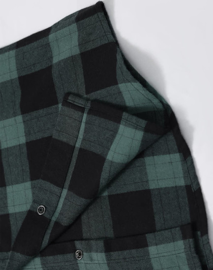 A unisex flannel plaid shirt featuring green and black check patterns, with button-up details and a logo.