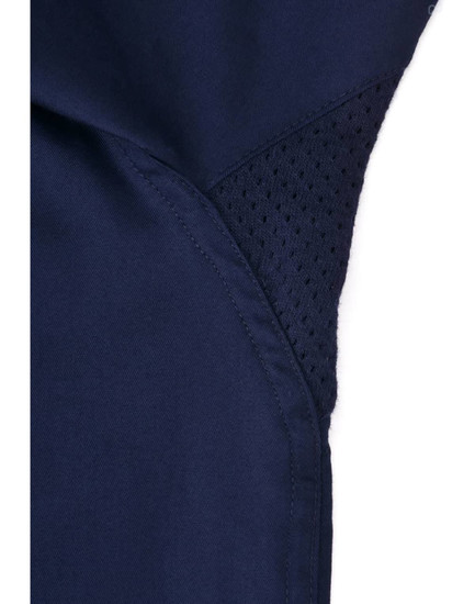A close-up of a navy blue work shirt featuring a mesh panel for ventilation, with stitching details visible.