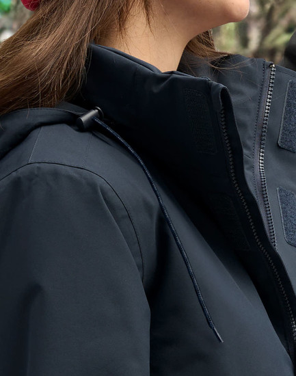 A unisex quilted waterproof jacket in navy blue, featuring a zip and adjustable hood, with a branding logo visible.