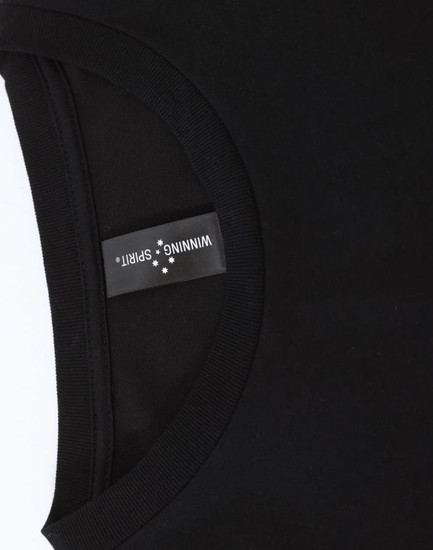 A close-up of a black long-sleeve tee with a round neckline, featuring a branded label inside the collar.