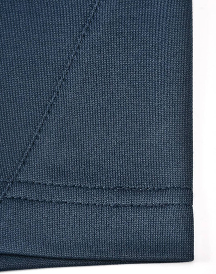 A close-up of a dark blue polo shirt fabric showing the seam detail and texture, featuring a logo.