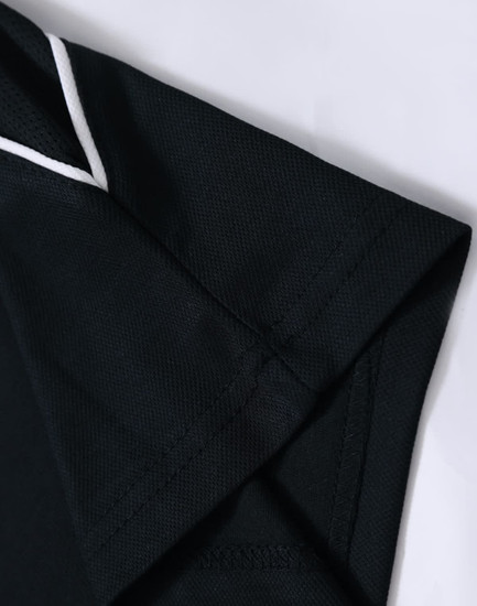 A black polo shirt featuring a collar and cuff detail, with a subtle logo on the sleeve.