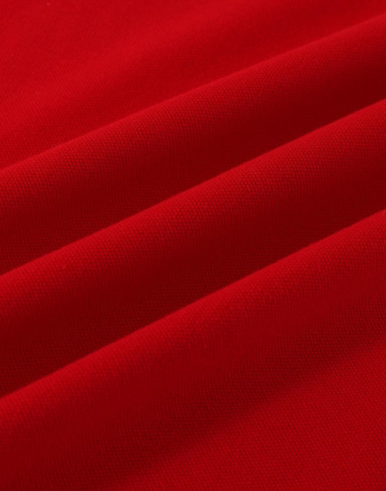 A vibrant red cotton stretch fabric with soft folds, suitable for polo shirts. Features a logo.
