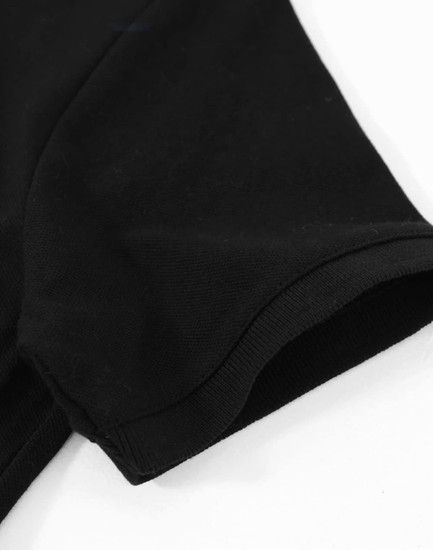 A close-up of a black cotton stretch polo shirt featuring a short sleeve and a rounded hem.