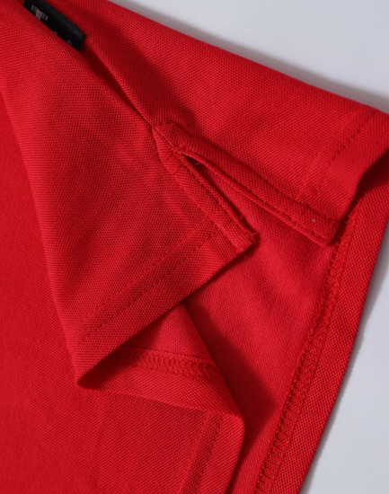 A red ladies' polo shirt displayed close-up, highlighting the collar and sleeve details. The shirt features a logo.
