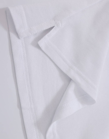 A close-up of a white polo shirt fabric, showcasing the collar and stitching details. Contains a logo.