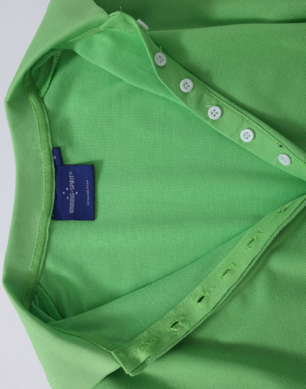 A green Ladies' Truedry Pique Polo shirt features a polo collar and button detail, with a brand label visible.