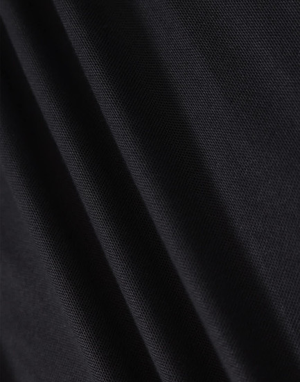 A close-up of black fabric showcasing the texture of a polo shirt. The material appears smooth and lightweight.